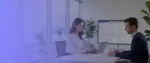 Microsoft 365 einführen: Zwei Mitarbeitende planen die Einführung von Microsoft 365 in einem modernen Büro mit Laptop, Monitor und strukturierter digitaler Arbeitsumgebung.